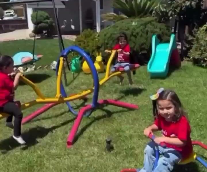 Kids playing on a colorful seesaw and slide in the backyard