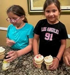 Two girls decorating ice cream cones