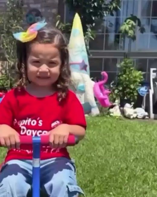 A smiling girl in a Pepito’s Daycare shirt riding a seesaw